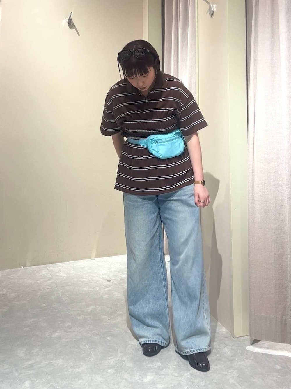 ブルー系のデニムパンツ、ブルー系のボディバッグ/ウエストポーチ、ブラウン系のローファーを着用したレディースの春コーディネートの8枚目の写真