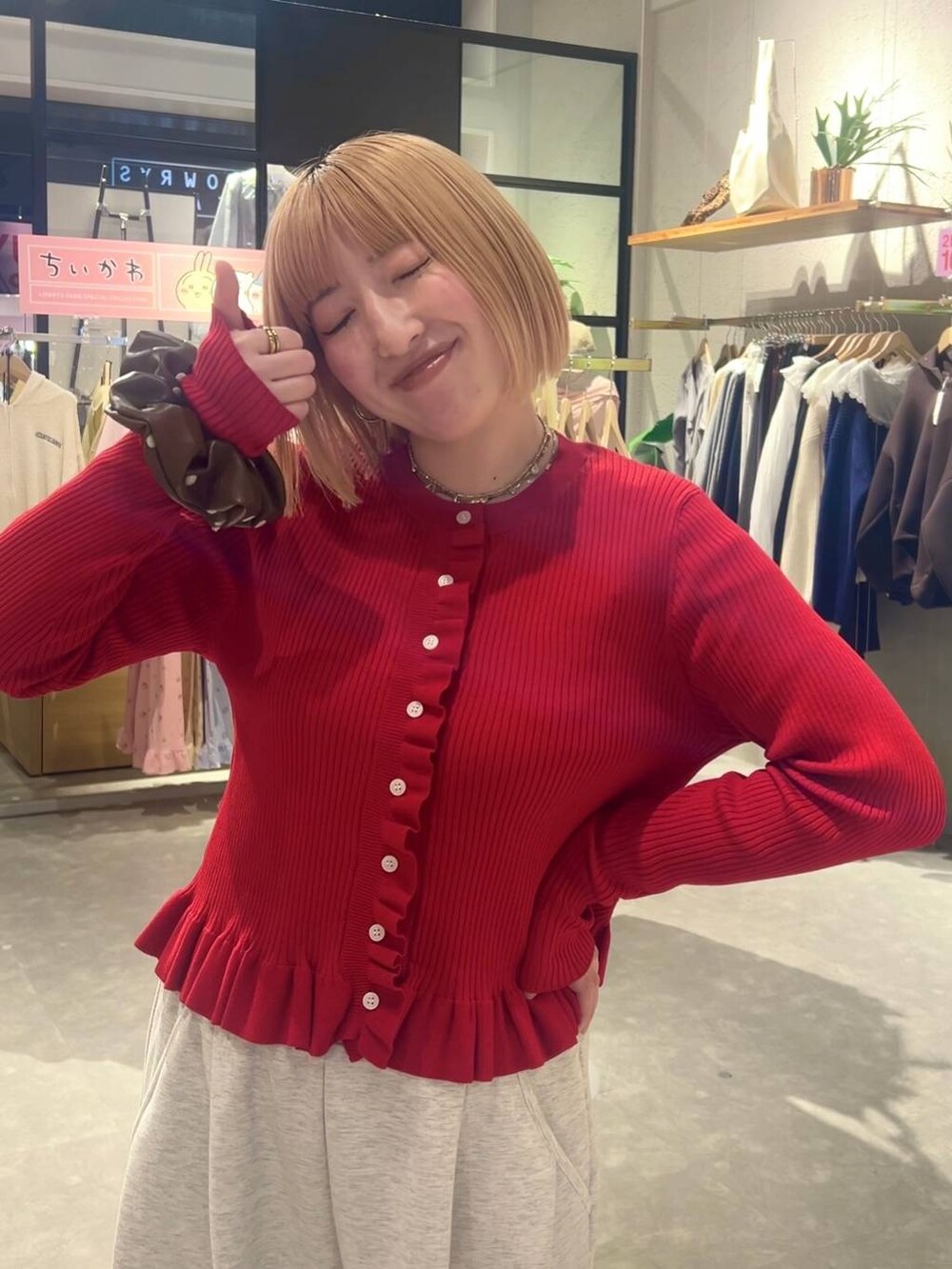グレー系のスウェットパンツ、レッド系のTシャツ/カットソー、ブラウン系のヘアゴムを着用したレディースの冬コーディネートの5枚目の写真