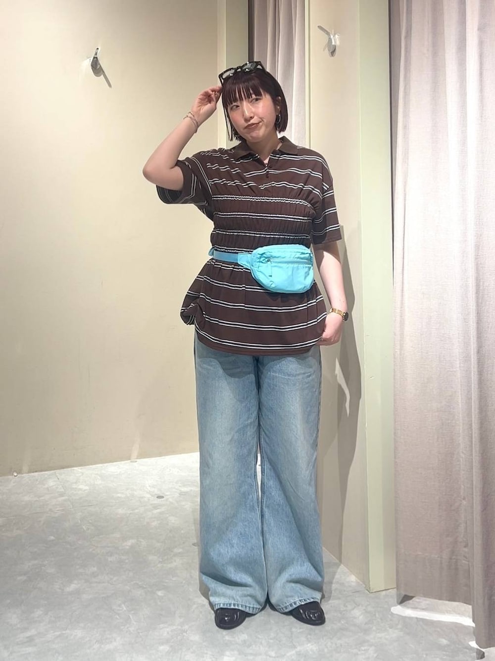 ブルー系のデニムパンツ、ブルー系のボディバッグ/ウエストポーチ、ブラウン系のローファーを着用したレディースの春コーディネートの6枚目の写真