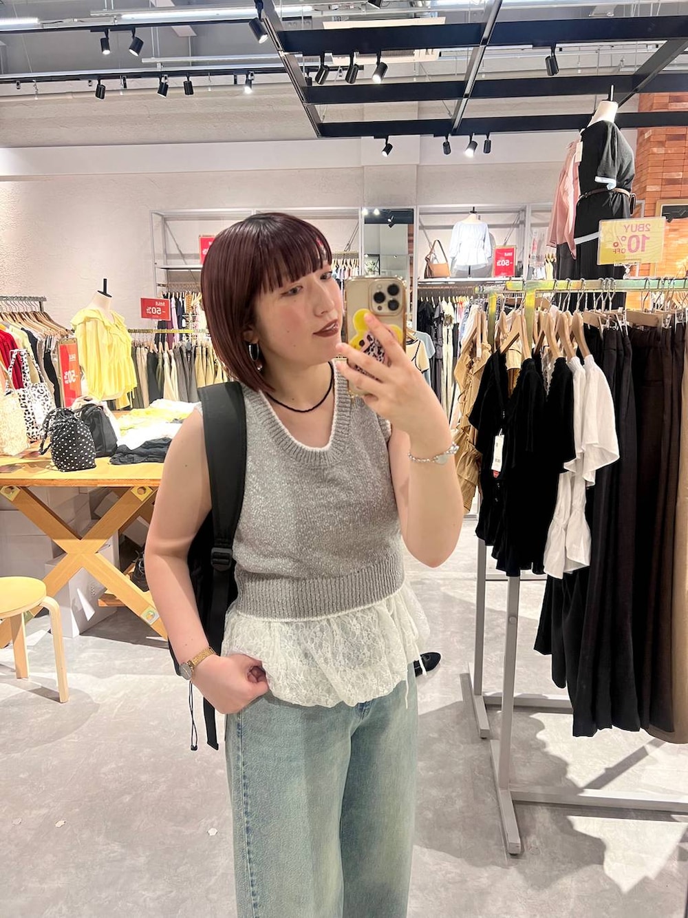 ブルー系のデニムパンツ、ブラック系のサンダル、グレー系のベストを着用したレディースの夏コーディネートの5枚目の写真