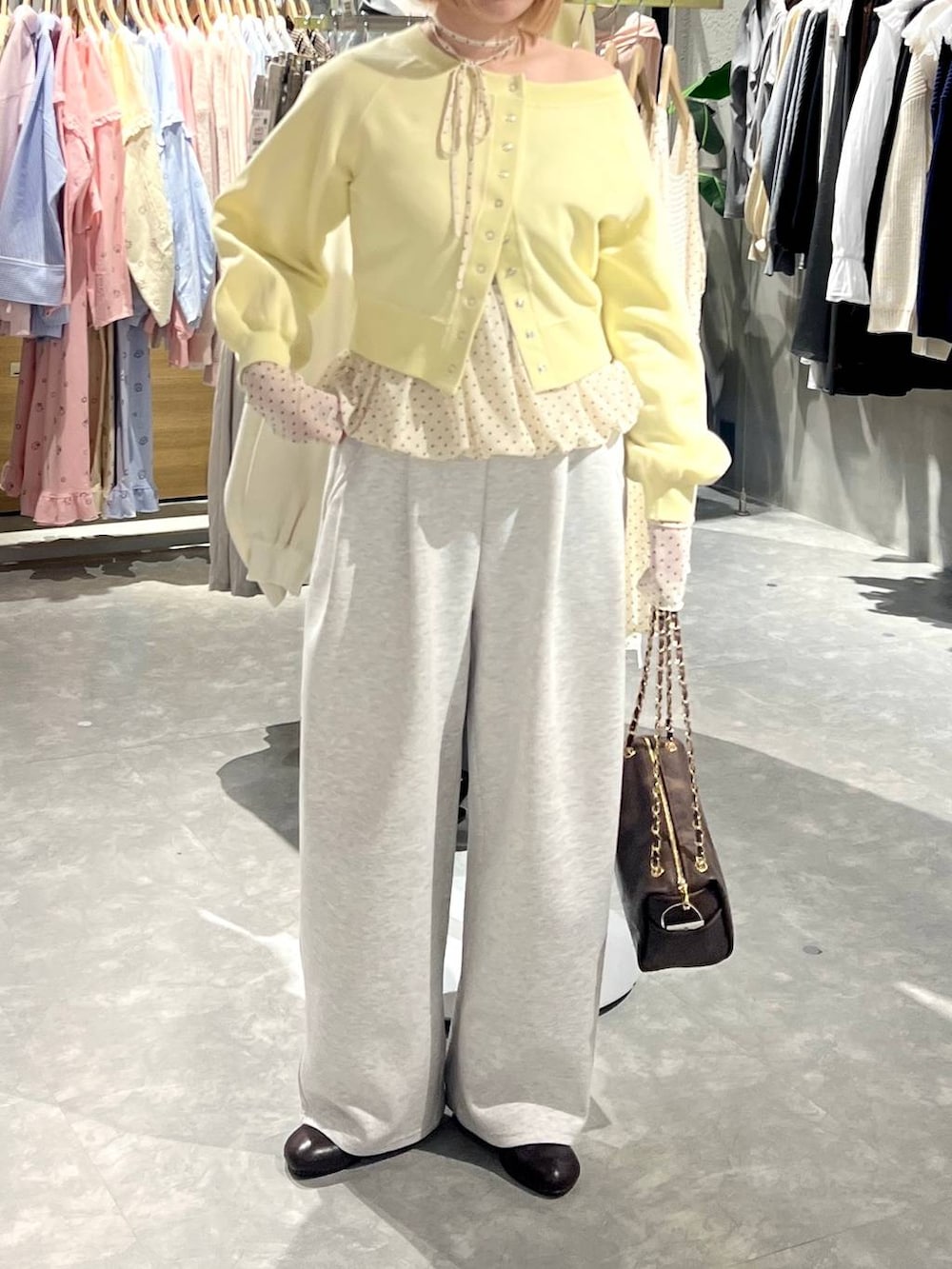 グレー系のスウェットパンツ、ブラウン系のショルダーバッグ、ブラウン系のサンダルを着用したレディースの冬コーディネートの2枚目の写真