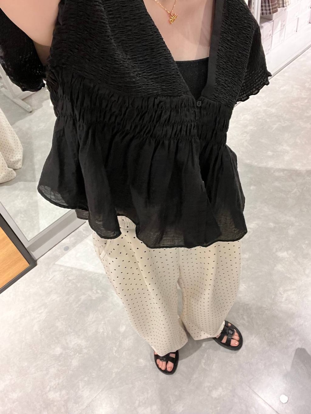 ホワイト系のスウェットパンツ、ブラック系のタンクトップ、ブラック系のサンダルを着用したレディースの夏コーディネートの5枚目の写真