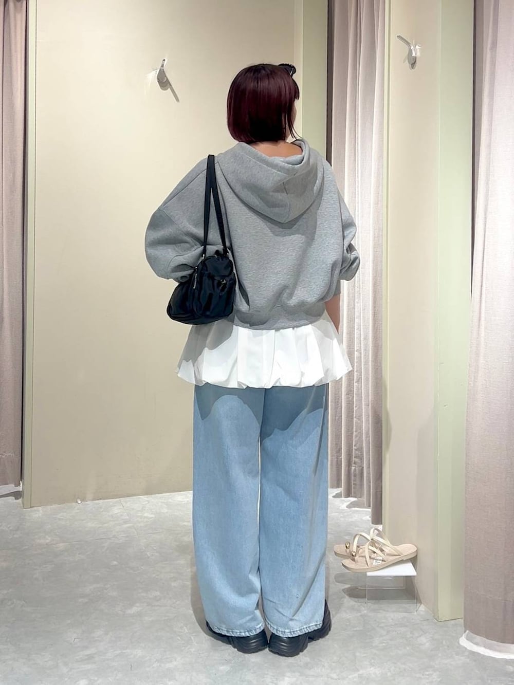 グレー系のパーカー、ブルー系のデニムパンツ、ブラック系のローファーを着用したレディースの秋コーディネートの3枚目の写真
