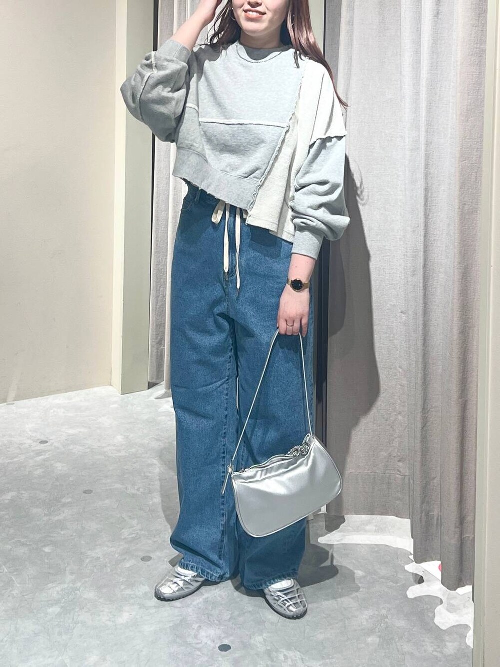 グレー系のスウェット、ブルー系のデニムパンツ、シルバー系のトートバッグを着用したレディースの春コーディネートの4枚目の写真