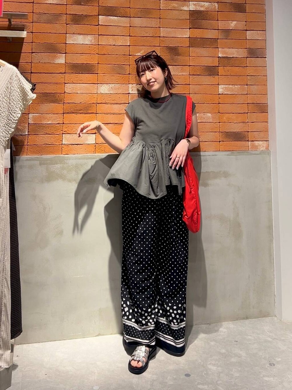 グレー系のTシャツ/カットソー、シルバー系のサンダル、レッド系のショルダーバッグを着用したレディースの夏コーディネートの6枚目の写真