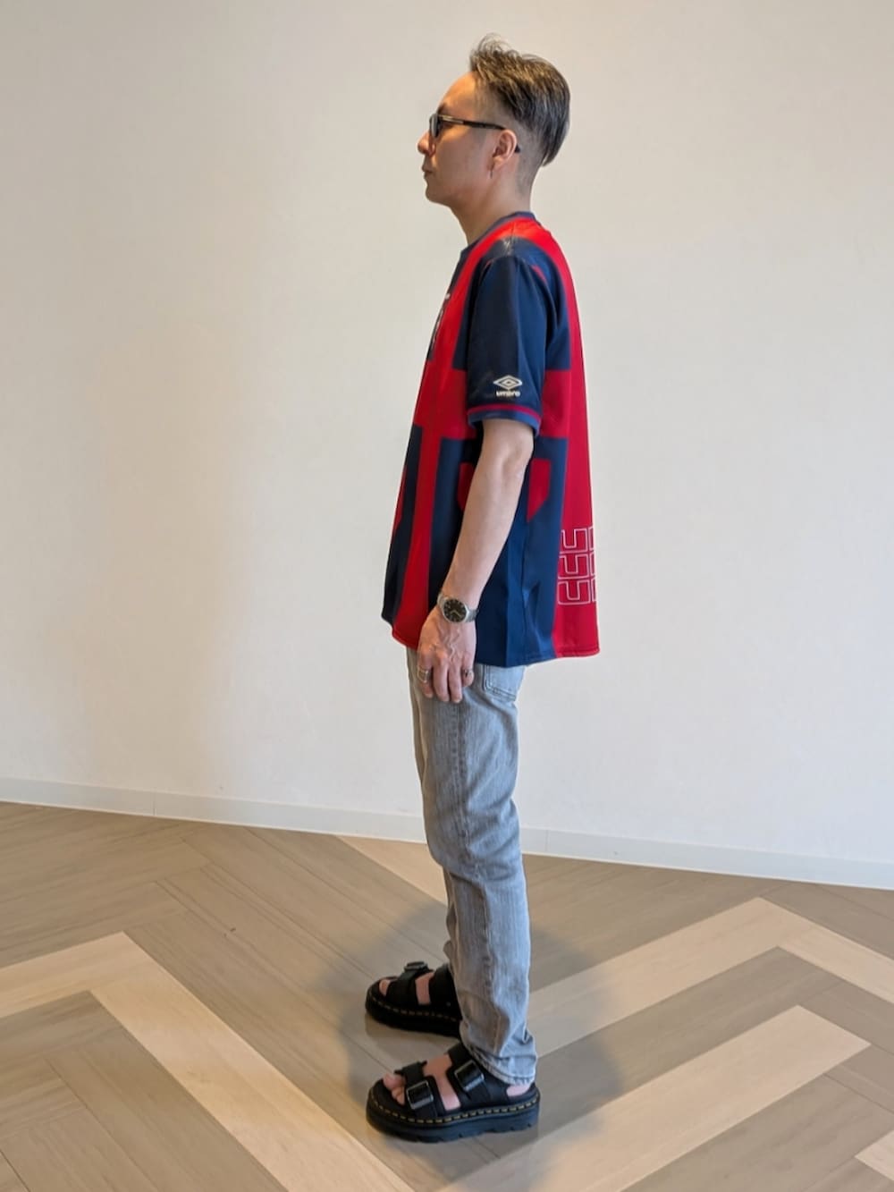 ブルー系のジャージ、グレー系のデニムパンツ、ブラック系のサンダルを着用したメンズの夏コーディネートの3枚目の写真