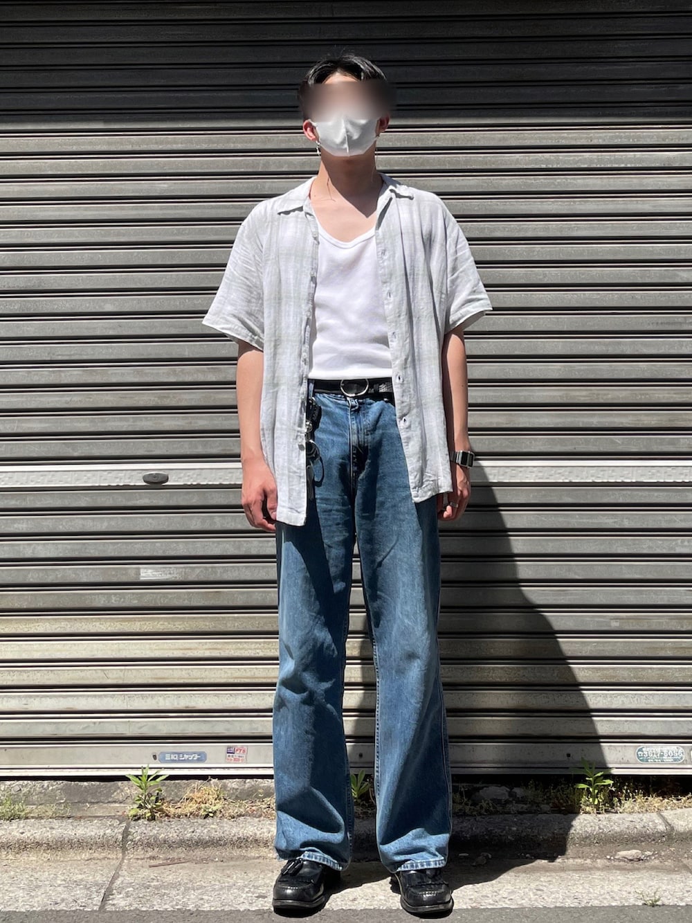 ベージュ系のバッグ、ブルー系のデニムパンツ、ブラック系のローファーを着用したメンズの春コーディネートの2枚目の写真