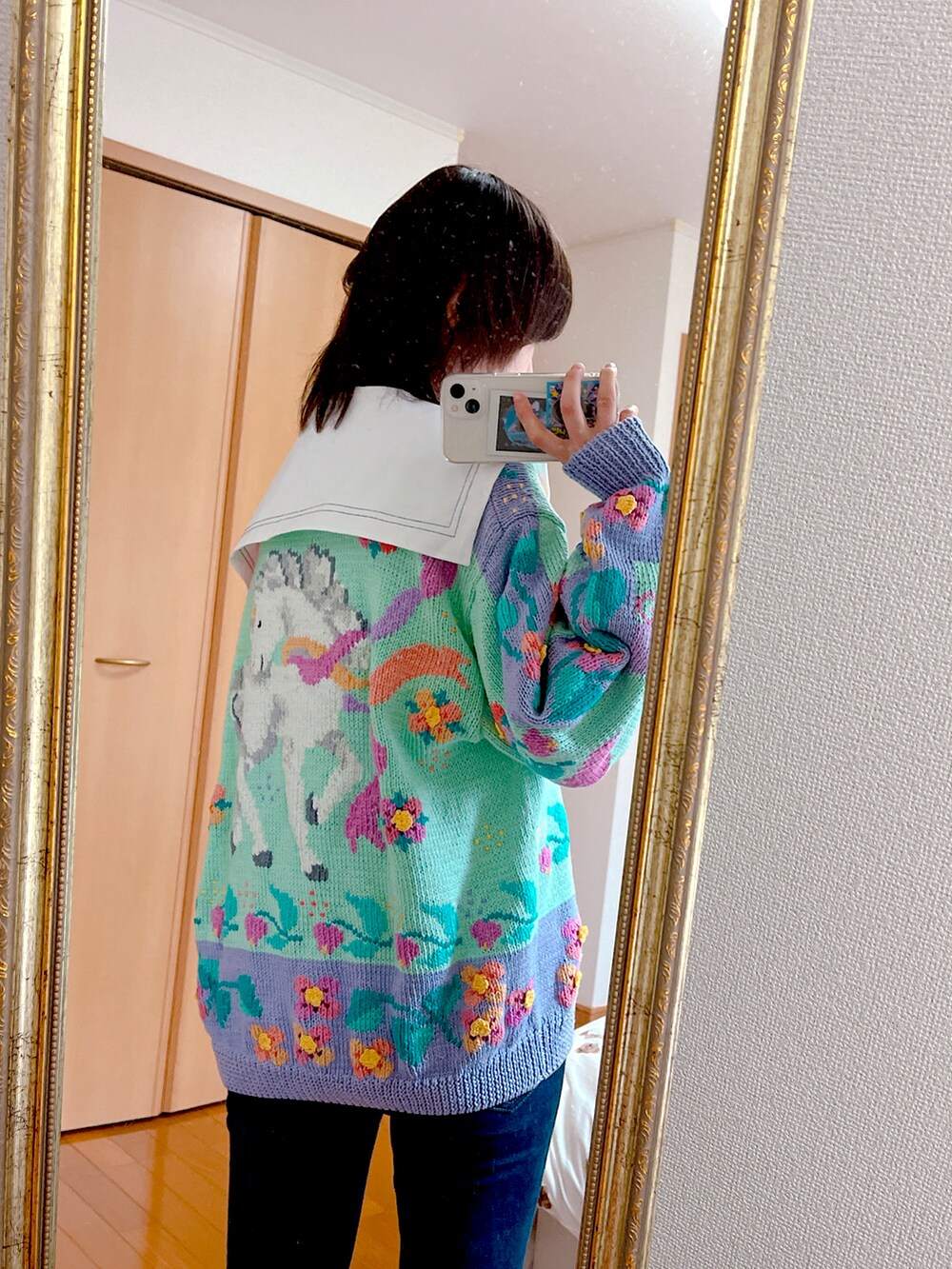 ブルー系のデニムパンツ、ホワイト系のシャツ/ブラウス、その他のニット/セーターを着用したレディースの春コーディネートの2枚目の写真