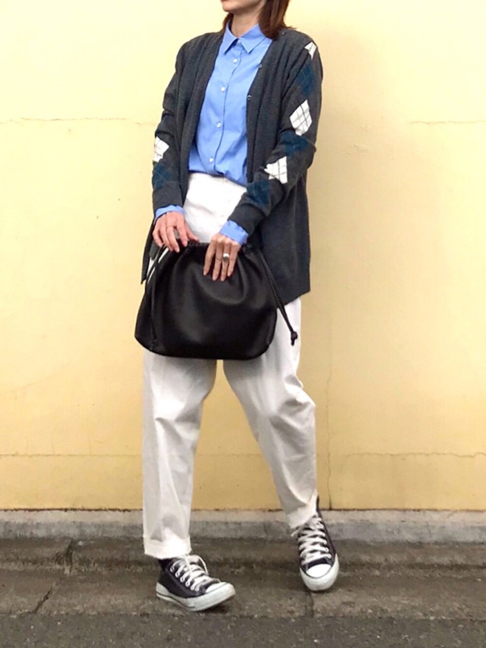 ブラウン系のハンドバッグ、ブラック系のスニーカー、ブルー系のシャツ/ブラウスを着用したレディースの冬コーディネートの2枚目の写真