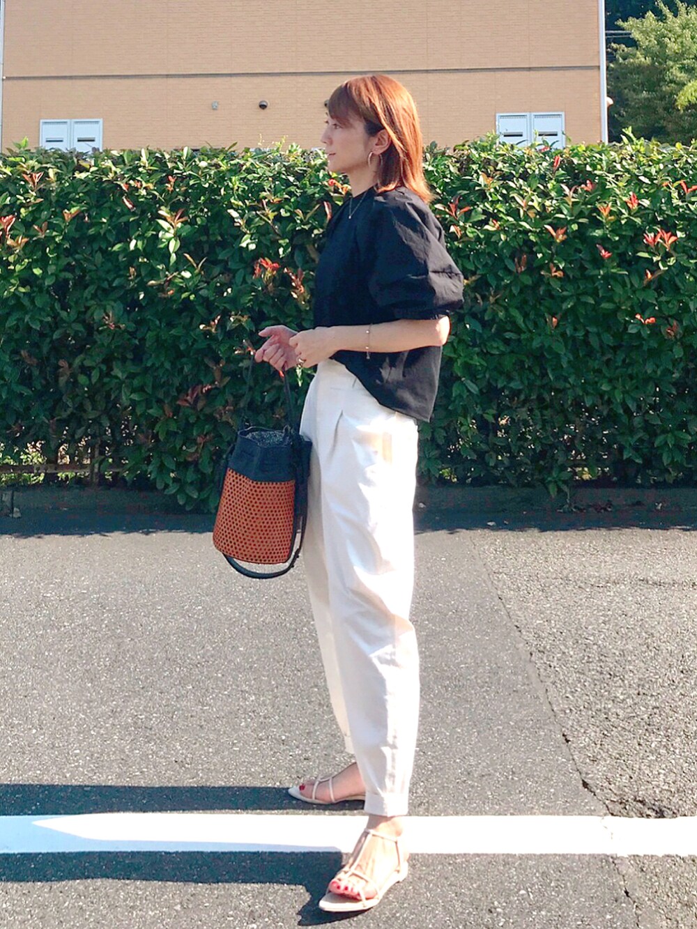 ブラック系のTシャツ/カットソー、ブラウン系のショルダーバッグ、ホワイト系のその他パンツを着用したレディースの夏コーディネートの2枚目の写真