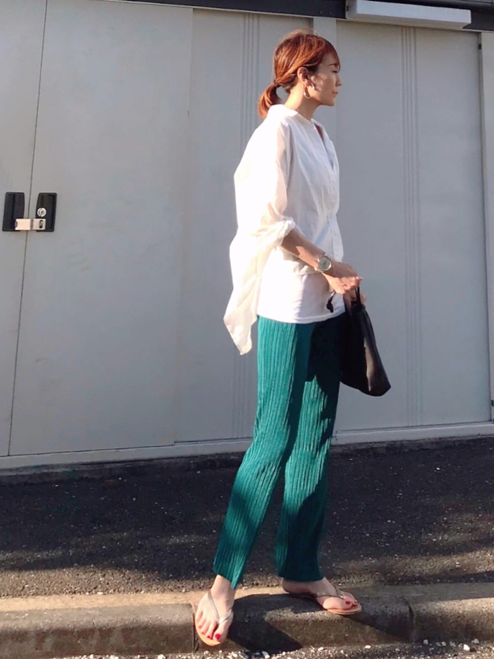 ブラウン系のハンドバッグ、ブルー系のその他パンツ、ゴールド系のサンダルを着用したレディースの夏コーディネートの4枚目の写真