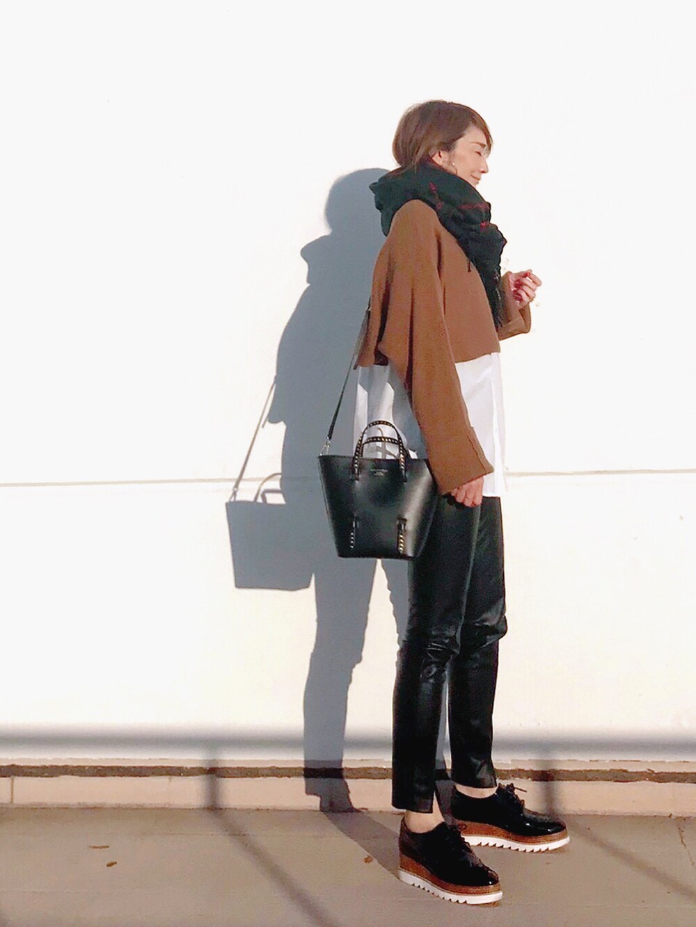 ホワイト系のシャツ/ブラウス、ベージュ系のニット/セーター、ブラック系のトートバッグを着用したレディースの秋コーディネートの4枚目の写真