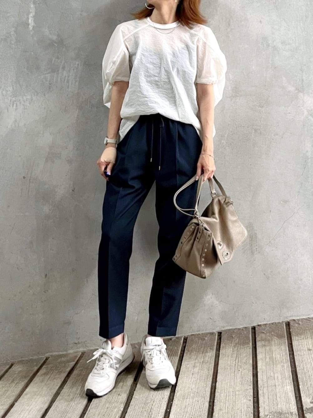 ブルー系のその他パンツ、ホワイト系のTシャツ/カットソー、グレー系のハンドバッグを着用したレディースの秋コーディネートの2枚目の写真