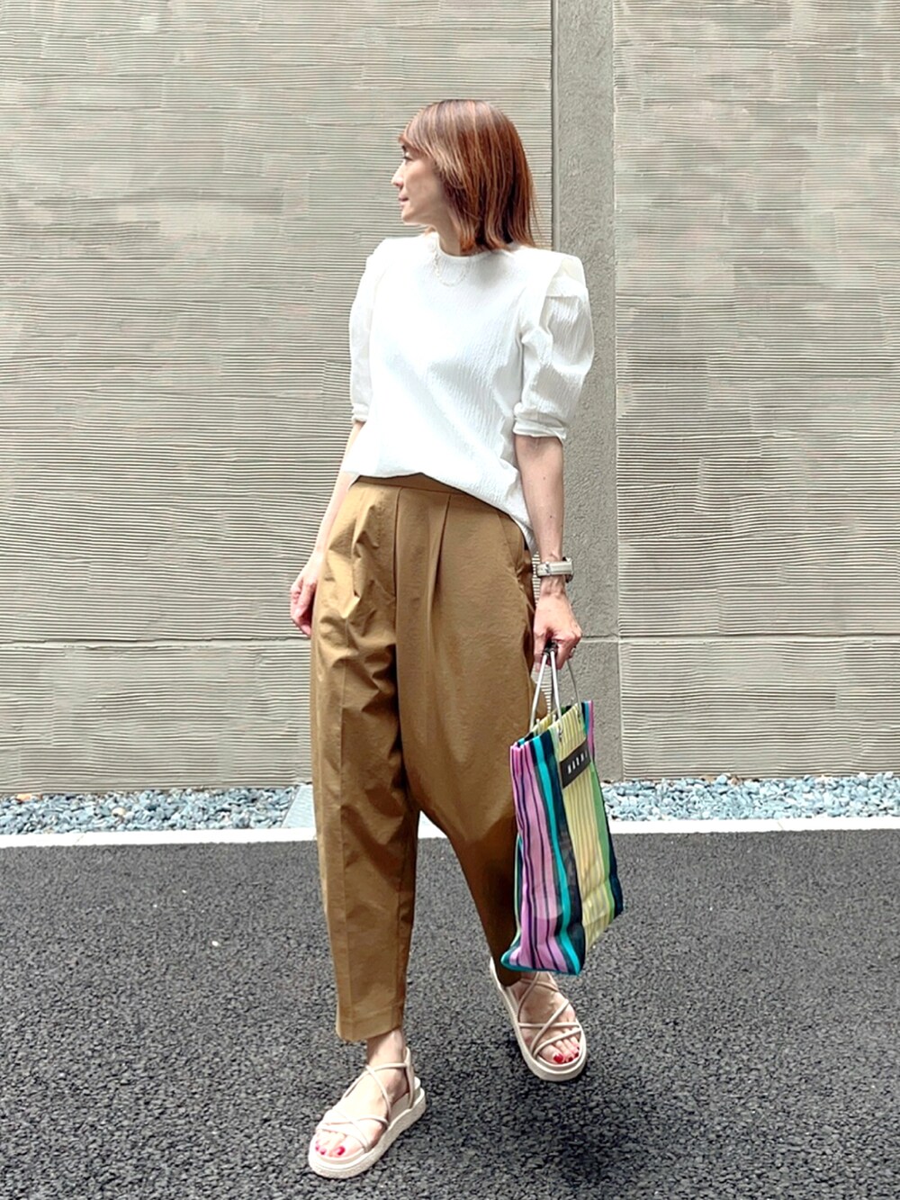 イエロー系のその他パンツ、ホワイト系のサンダル、その他のバッグを着用したレディースの夏コーディネートの3枚目の写真