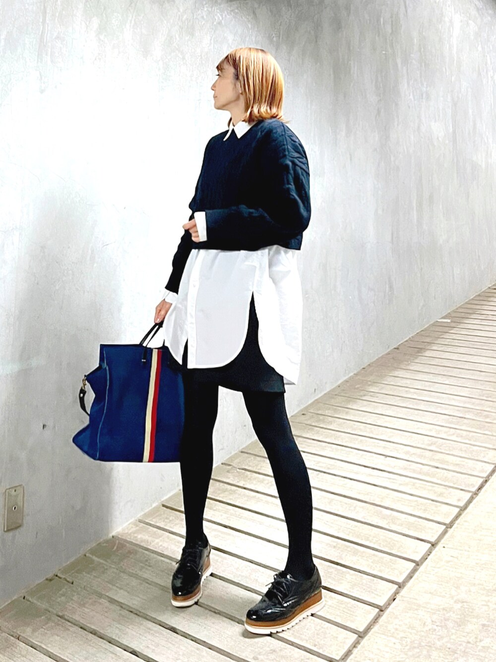 ブルー系のニット/セーター、ホワイト系のシャツ/ブラウス、ブラック系のドレスシューズを着用したレディースの冬コーディネートの2枚目の写真