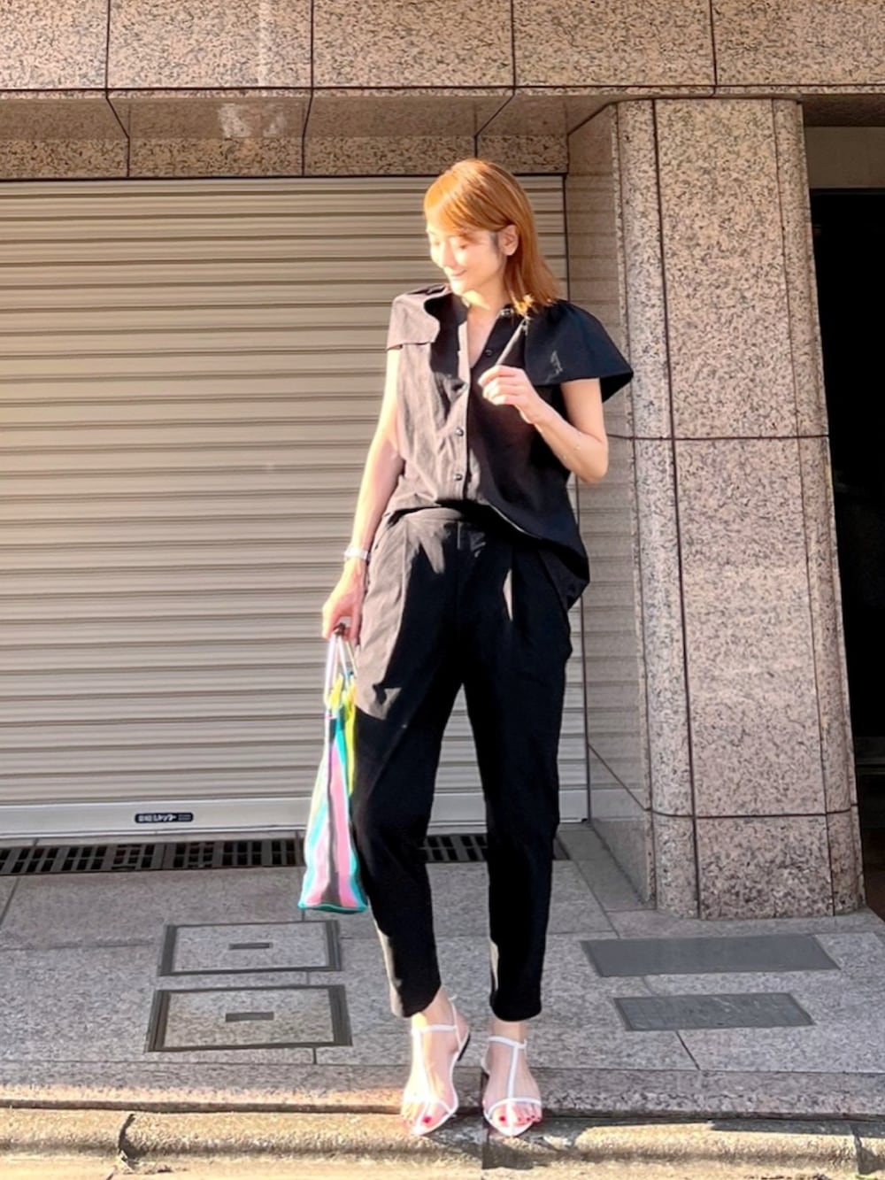 ブラック系のシャツ/ブラウス、ブラック系のパンツ、ホワイト系のサンダルを着用したレディースの夏コーディネートの2枚目の写真