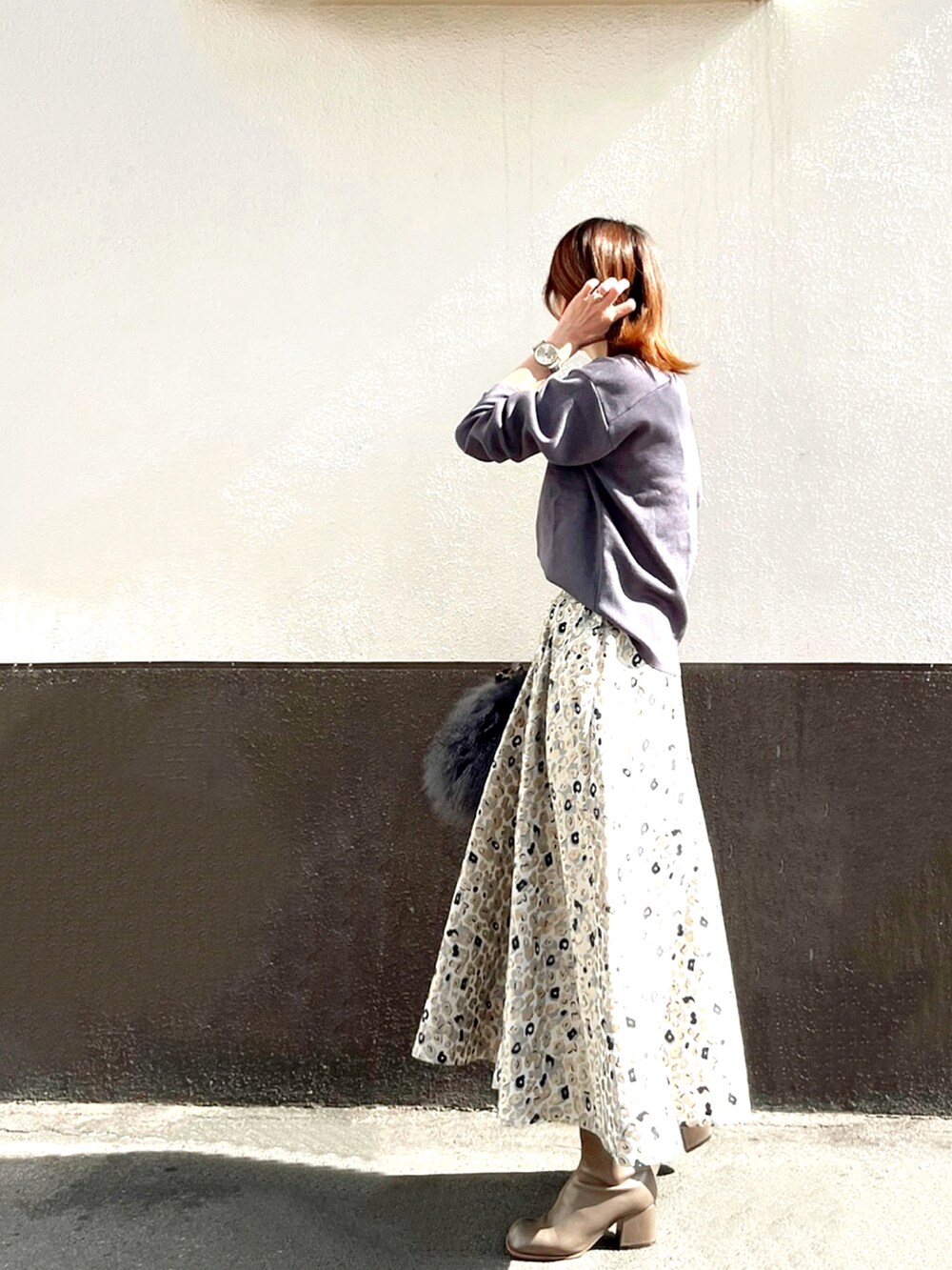 ベージュ系のスカート、ベージュ系のブーツ、グレー系のニット/セーターを着用したレディースの秋コーディネートの4枚目の写真