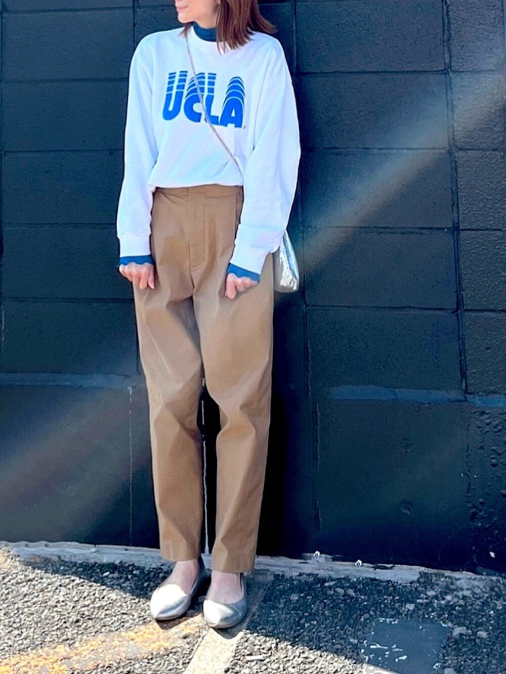 ホワイト系のスウェット、シルバー系のハンドバッグ、ブルー系のTシャツ/カットソーを着用したレディースの春コーディネートの2枚目の写真