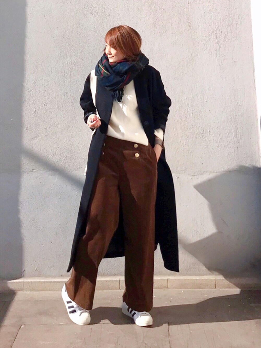 ブラウン系のその他パンツ、ホワイト系のニット/セーター、ホワイト系のスニーカーを着用したレディースの秋コーディネートの2枚目の写真