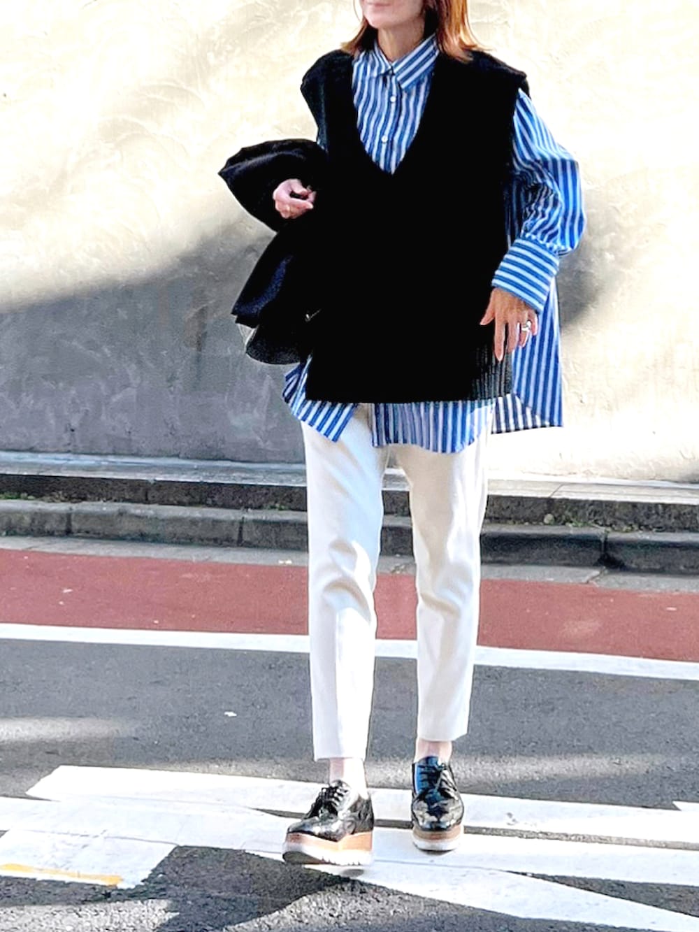 ブルー系のシャツ/ブラウス、ブラック系のドレスシューズ、ブラック系のニット/セーターを着用したレディースの秋コーディネートの3枚目の写真