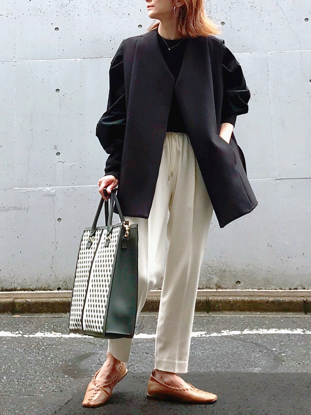 ブラック系のトートバッグ、ブラック系のニット/セーター、ブラック系のその他アウターを着用したレディースの夏コーディネートの2枚目の写真