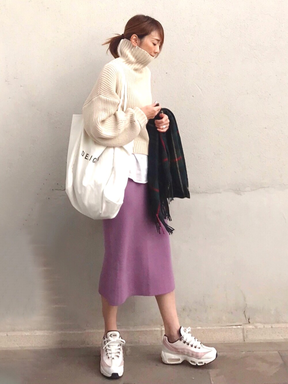 ピンク系のスカート、ベージュ系のニット/セーター、ホワイト系のスニーカーを着用したレディースの秋コーディネートの3枚目の写真