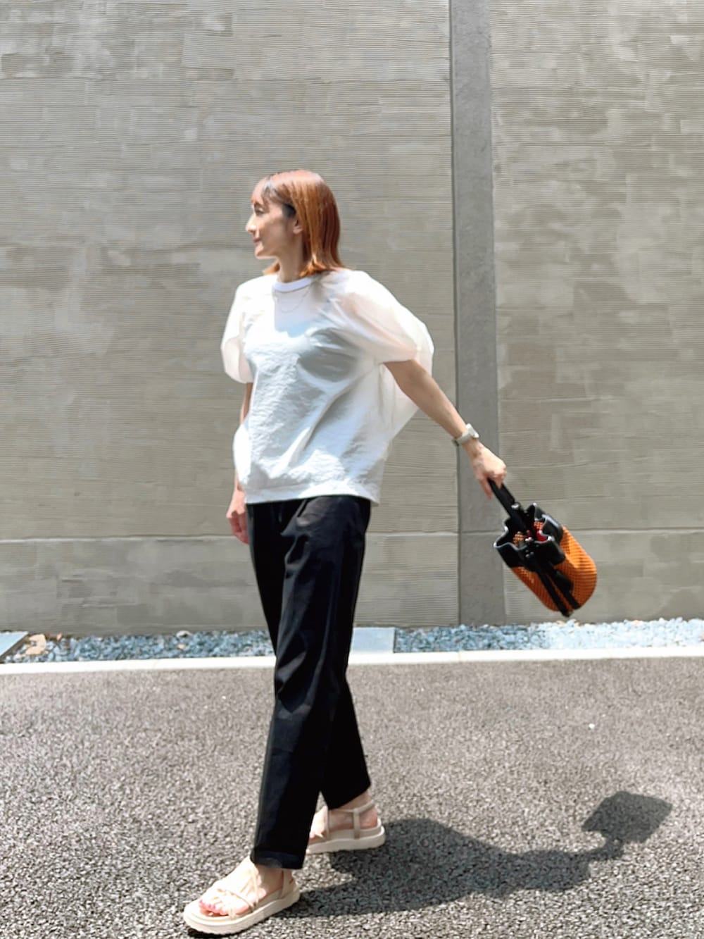 ホワイト系のTシャツ/カットソー、ブラウン系のショルダーバッグ、ブラック系のその他パンツを着用したレディースの夏コーディネートの2枚目の写真