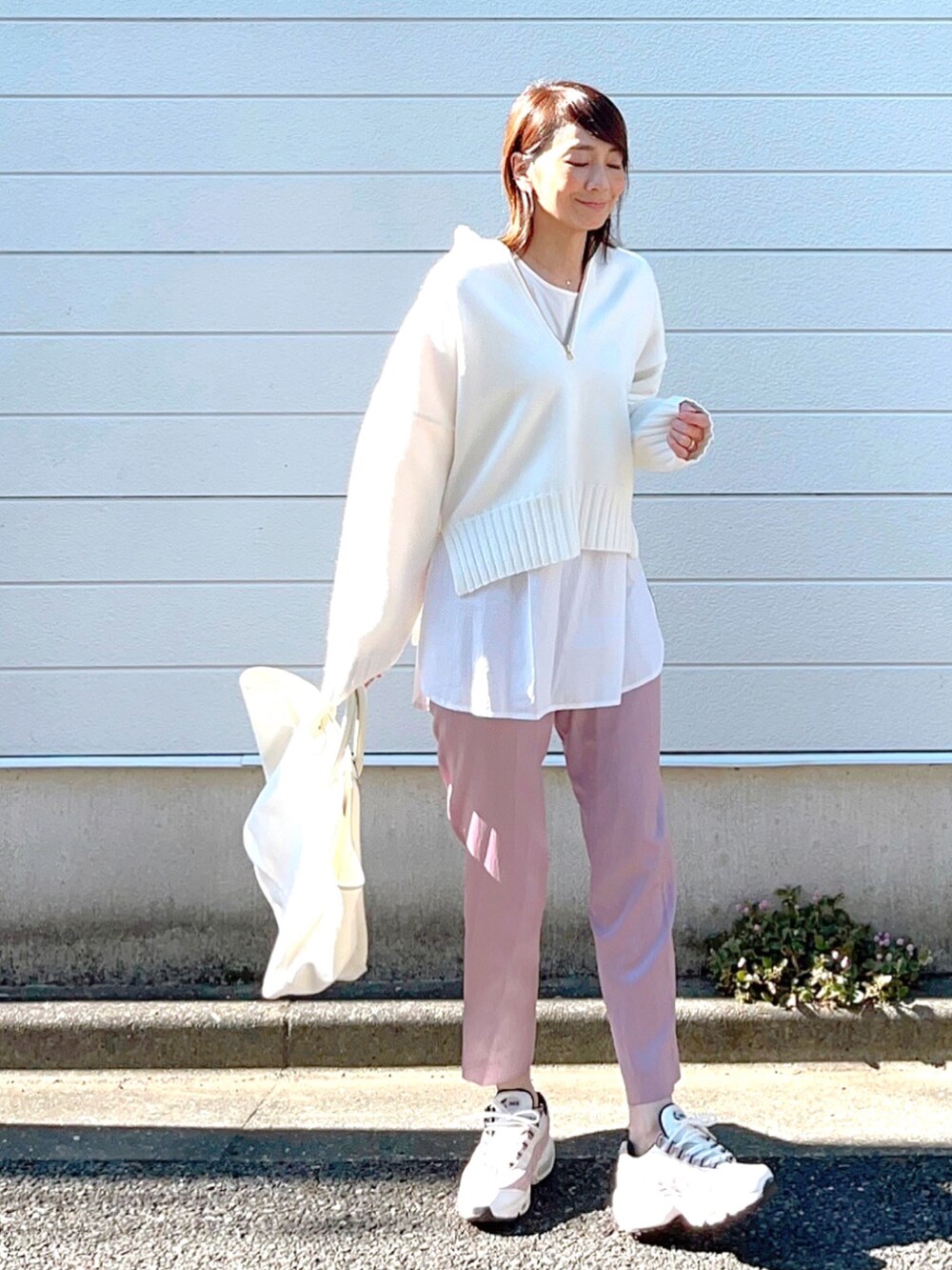 ホワイト系のニット/セーター、ホワイト系のスニーカー、ホワイト系のトートバッグを着用したレディースの秋コーディネートの3枚目の写真