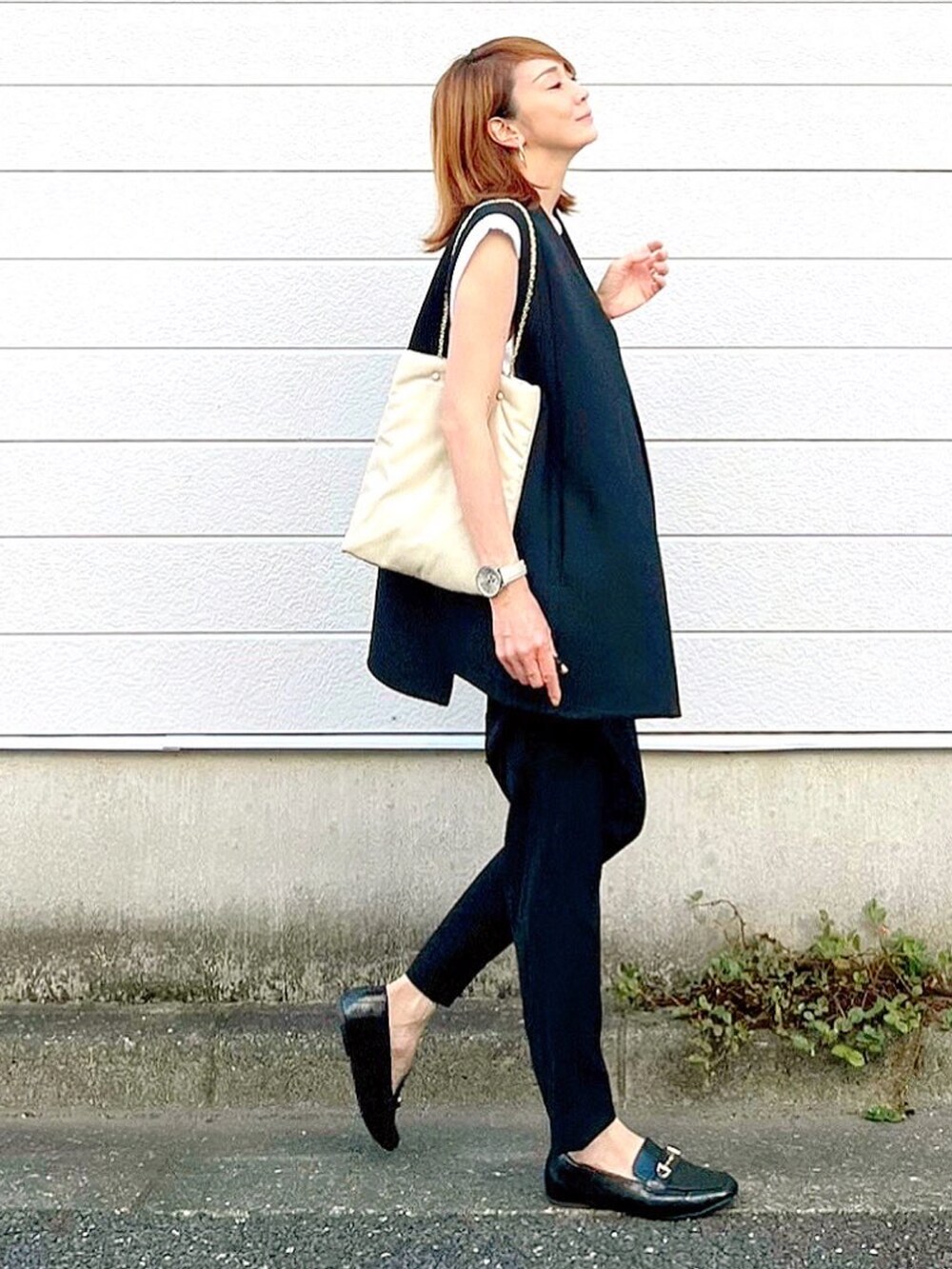 ホワイト系のトートバッグ、ブラック系のその他アウター、ブラック系のその他パンツを着用したレディースの秋コーディネートの2枚目の写真