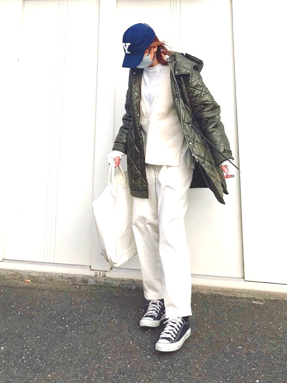グリーン系のブルゾン、ホワイト系のトートバッグ、ブラック系のスニーカーを着用したレディースの冬コーディネートの2枚目の写真