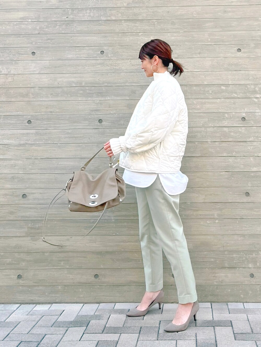 ホワイト系のその他アウター、グレー系のハンドバッグ、ホワイト系のニット/セーターを着用したレディースの冬コーディネートの3枚目の写真