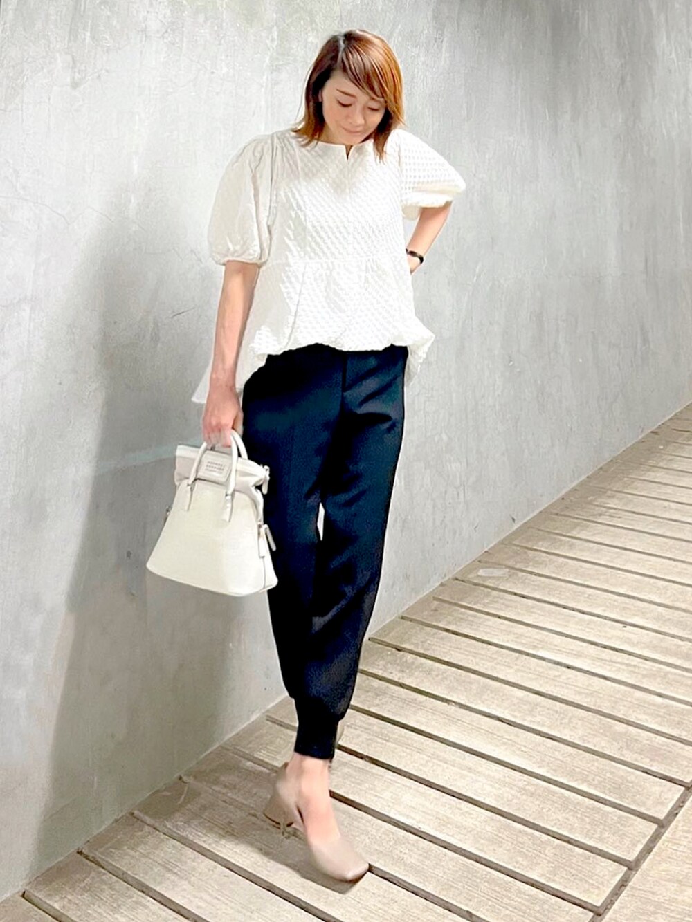 ホワイト系のハンドバッグ、グレー系のパンプス、ブラック系のその他パンツを着用したレディースの春コーディネートの4枚目の写真