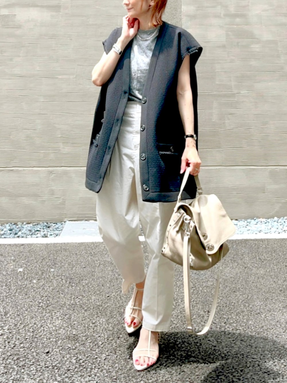 ホワイト系のその他パンツ、ブラック系のノーカラージャケット、グレー系のハンドバッグを着用したレディースの夏コーディネートの2枚目の写真