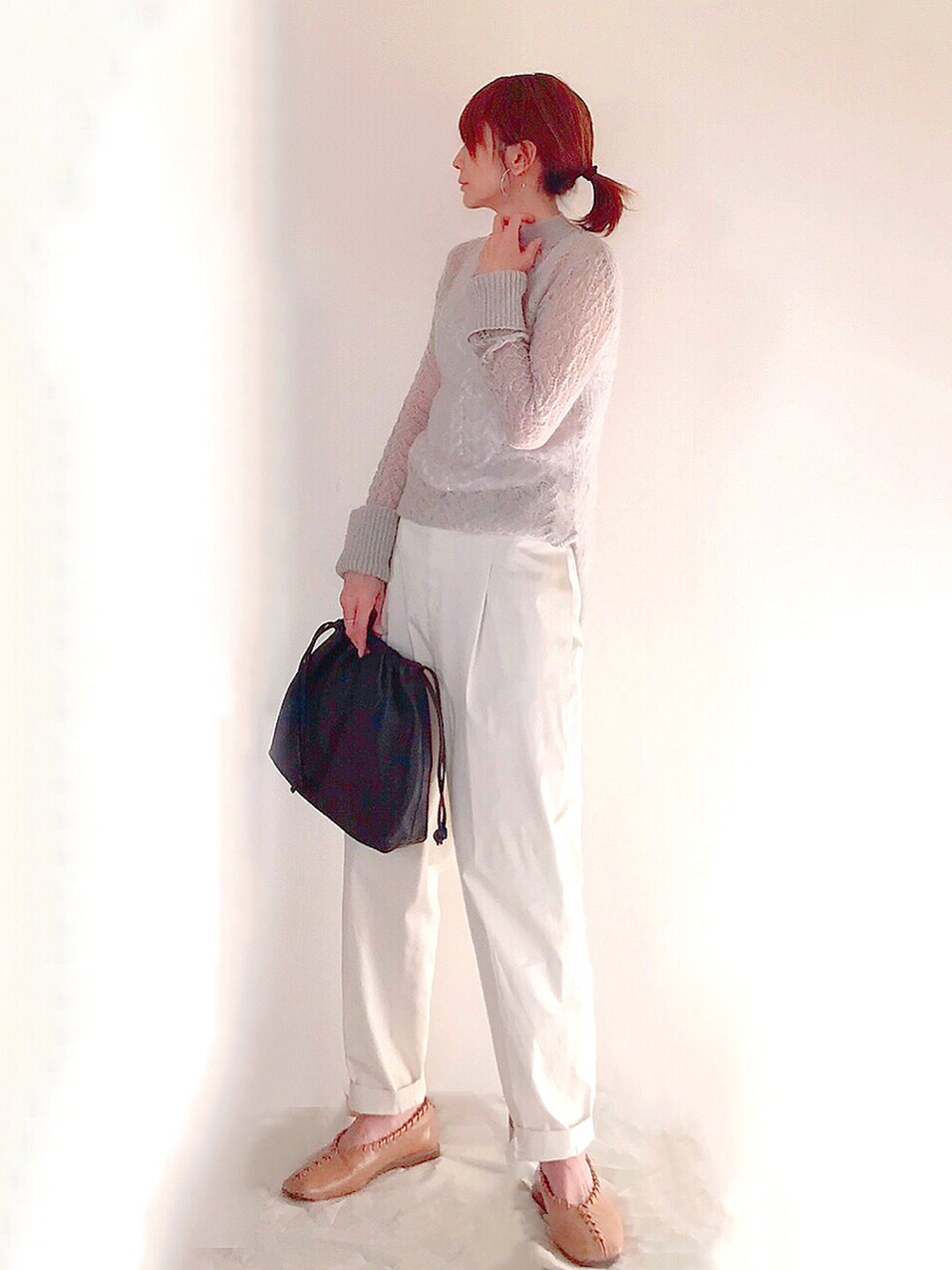 グレー系のニット/セーター、ブラウン系のハンドバッグ、ホワイト系のその他パンツを着用したレディースの冬コーディネートの3枚目の写真