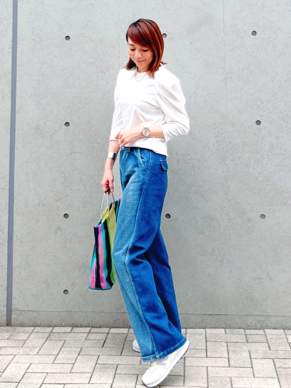 ブルー系のデニムパンツ、ホワイト系のTシャツ/カットソー、その他のバッグを着用したレディースの春コーディネートの3枚目の写真