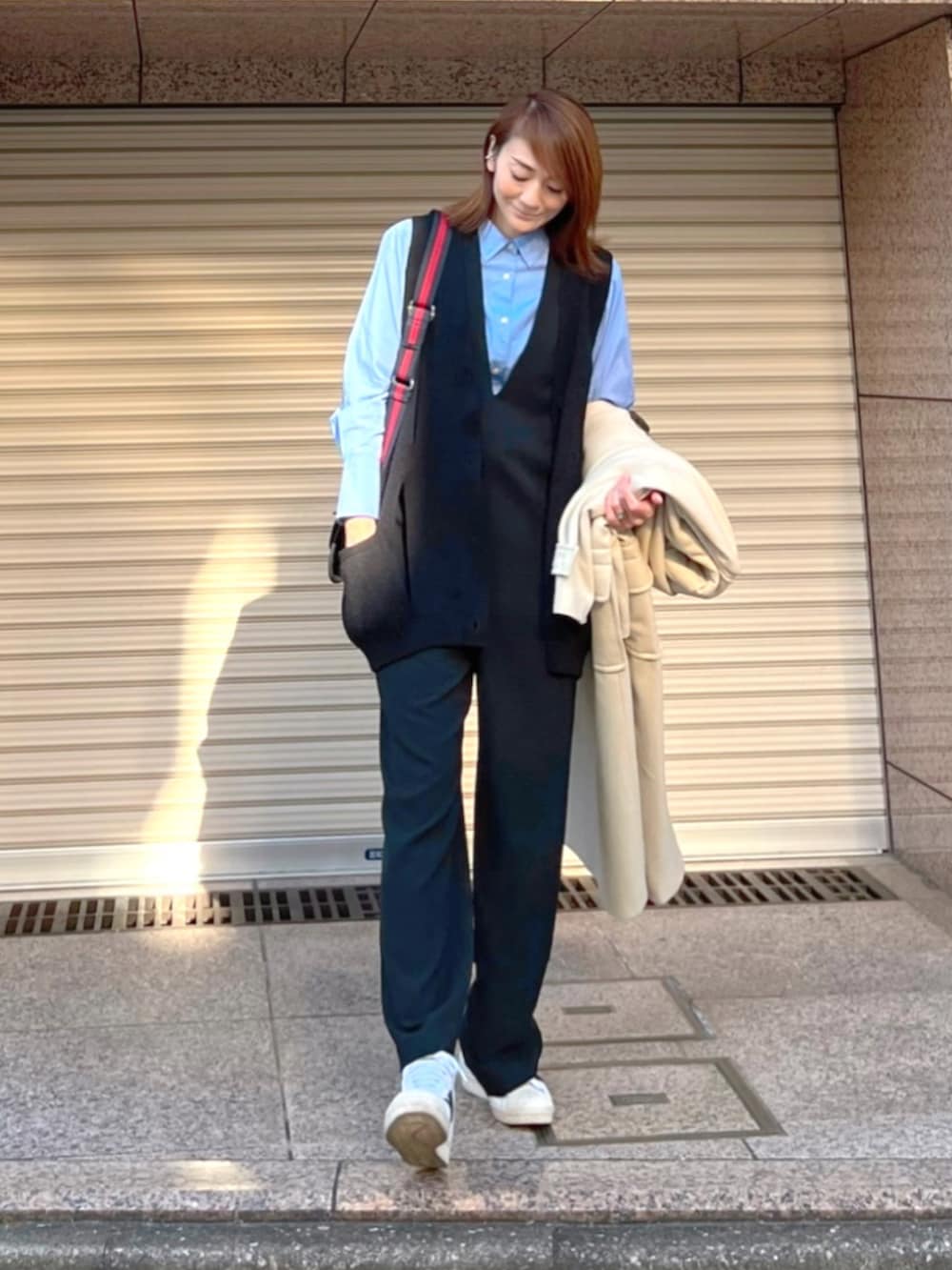 ブラック系のショルダーバッグ、ブラック系のカーディガン/ボレロ、ブラック系のつなぎ/オールインワンを着用したレディースの冬コーディネートの2枚目の写真