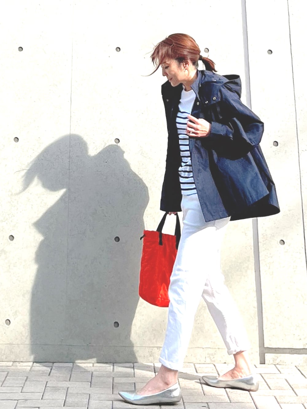 ブルー系のマウンテンパーカー、ホワイト系のTシャツ/カットソー、オレンジ系のトートバッグを着用したレディースの春コーディネートの2枚目の写真