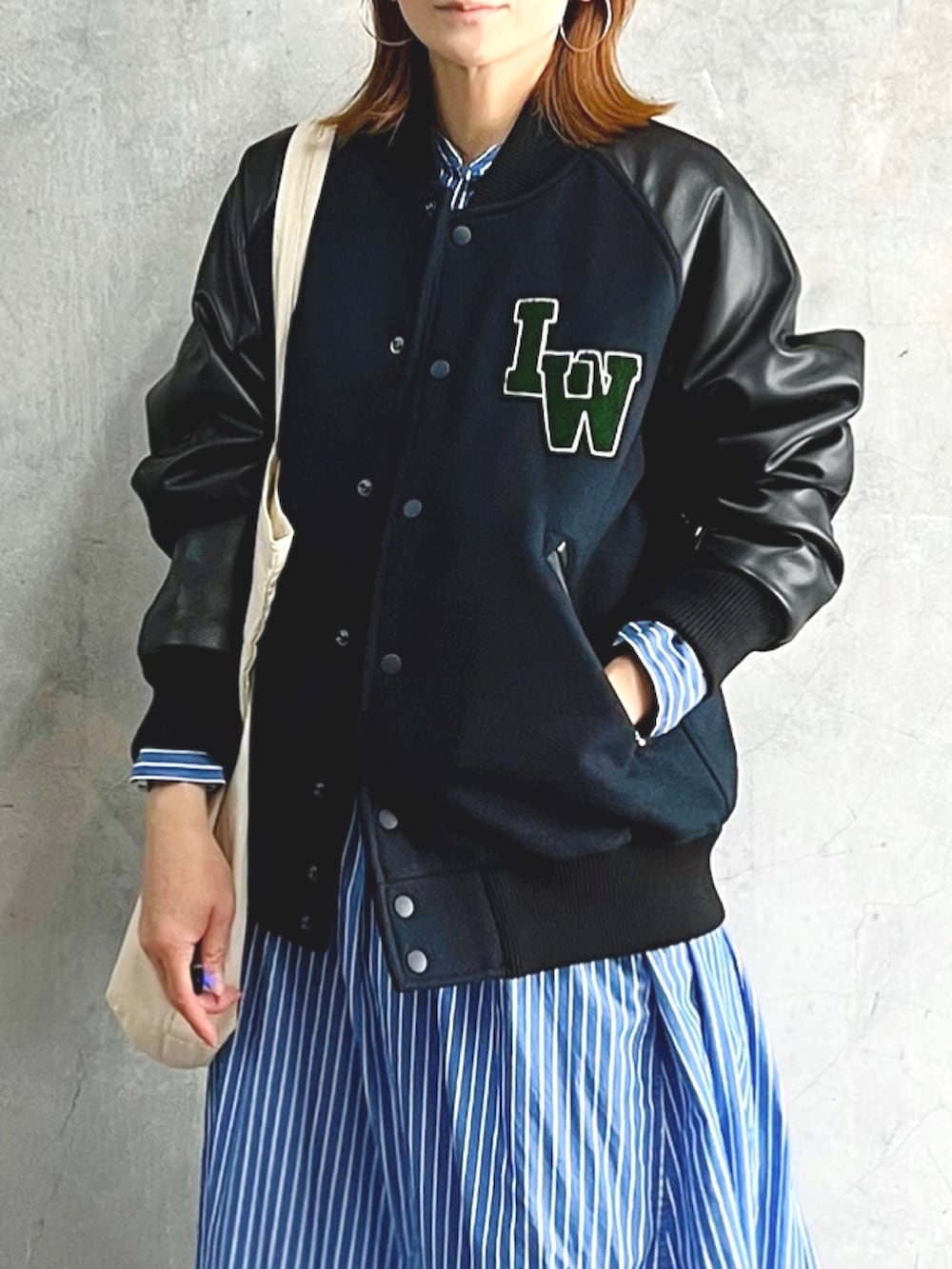 ブラック系のスタジャン、ブルー系のワンピース、シルバー系のシューズを着用したレディースの秋コーディネートの3枚目の写真