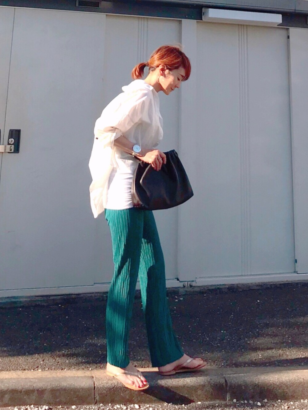 ブラウン系のハンドバッグ、ブルー系のその他パンツ、ゴールド系のサンダルを着用したレディースの夏コーディネートの3枚目の写真