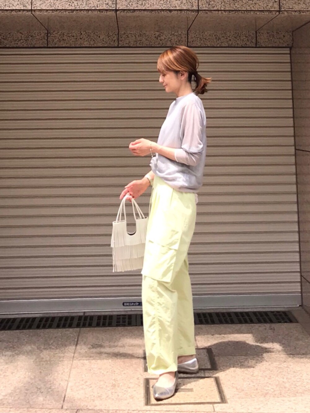 グリーン系のその他パンツ、グレー系のニット/セーター、ホワイト系のショルダーバッグを着用したレディースの春コーディネートの2枚目の写真