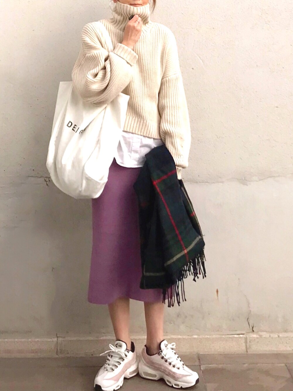 ピンク系のスカート、ベージュ系のニット/セーター、ホワイト系のスニーカーを着用したレディースの秋コーディネートの2枚目の写真
