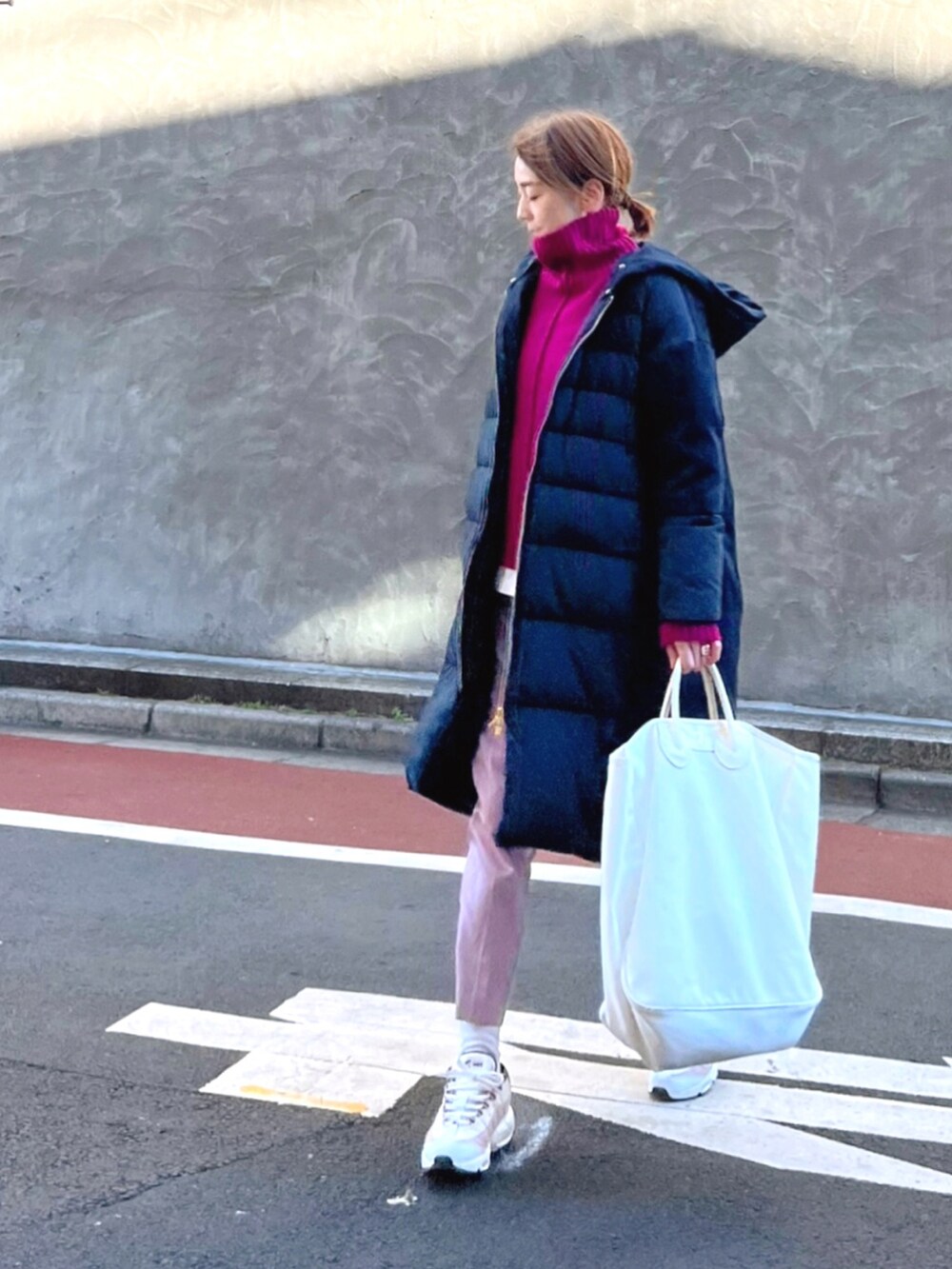 パープル系のニット/セーター、ブルー系のダウンジャケット/コート、パープル系のその他パンツを着用したレディースの冬コーディネートの2枚目の写真