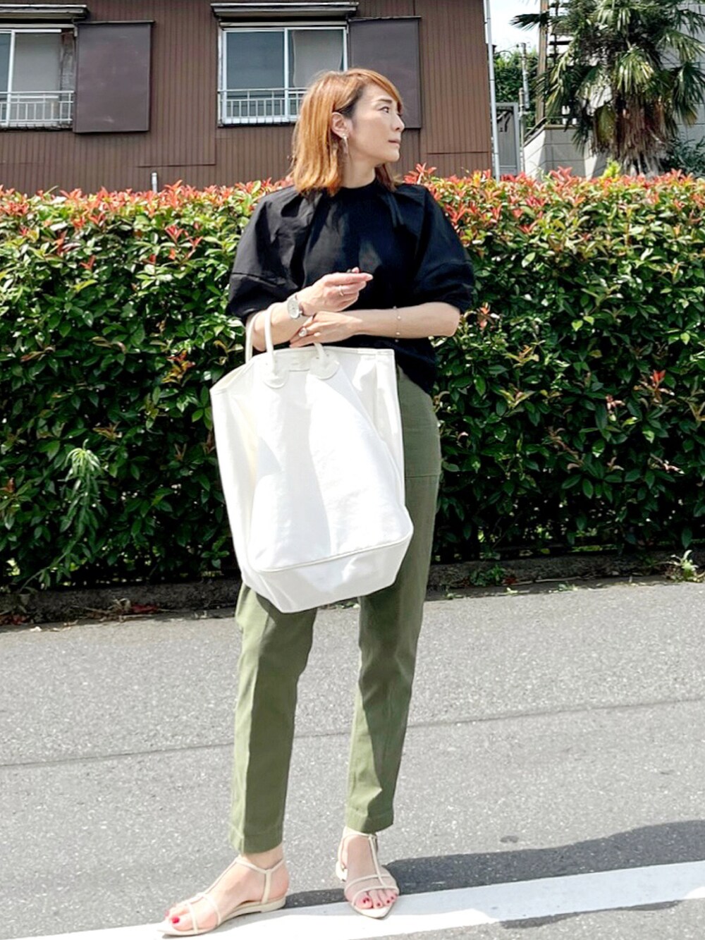 ブラック系のTシャツ/カットソー、ホワイト系のサンダル、ホワイト系のトートバッグを着用したレディースの夏コーディネートの2枚目の写真