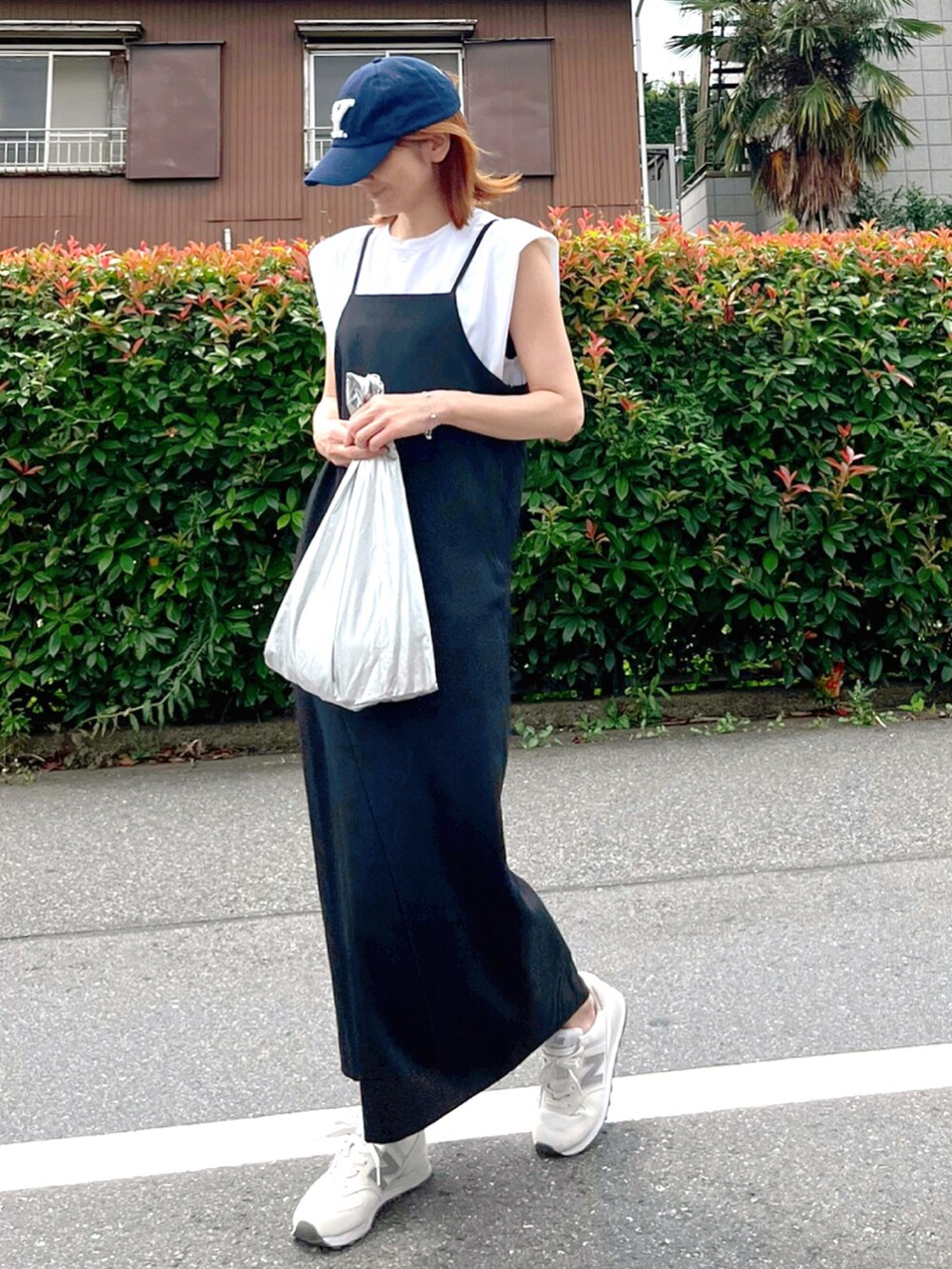 ブラック系のワンピース、ホワイト系のスニーカー、ホワイト系のTシャツ/カットソーを着用したレディースの夏コーディネートの2枚目の写真