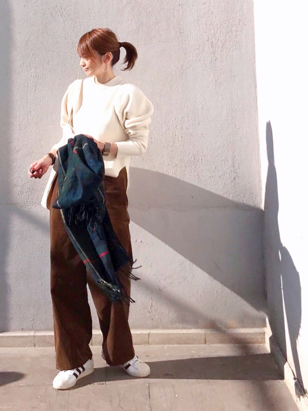 ブラウン系のその他パンツ、ホワイト系のニット/セーター、ホワイト系のトートバッグを着用したレディースの秋コーディネートの4枚目の写真