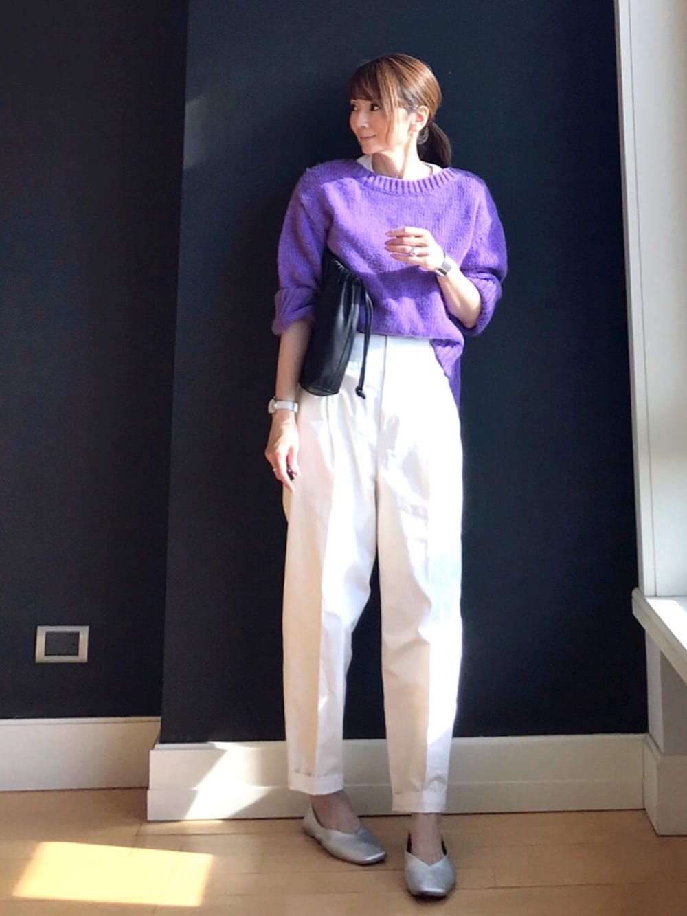 パープル系のニット/セーター、ブラウン系のハンドバッグ、ホワイト系のその他パンツを着用したレディースの冬コーディネートの3枚目の写真