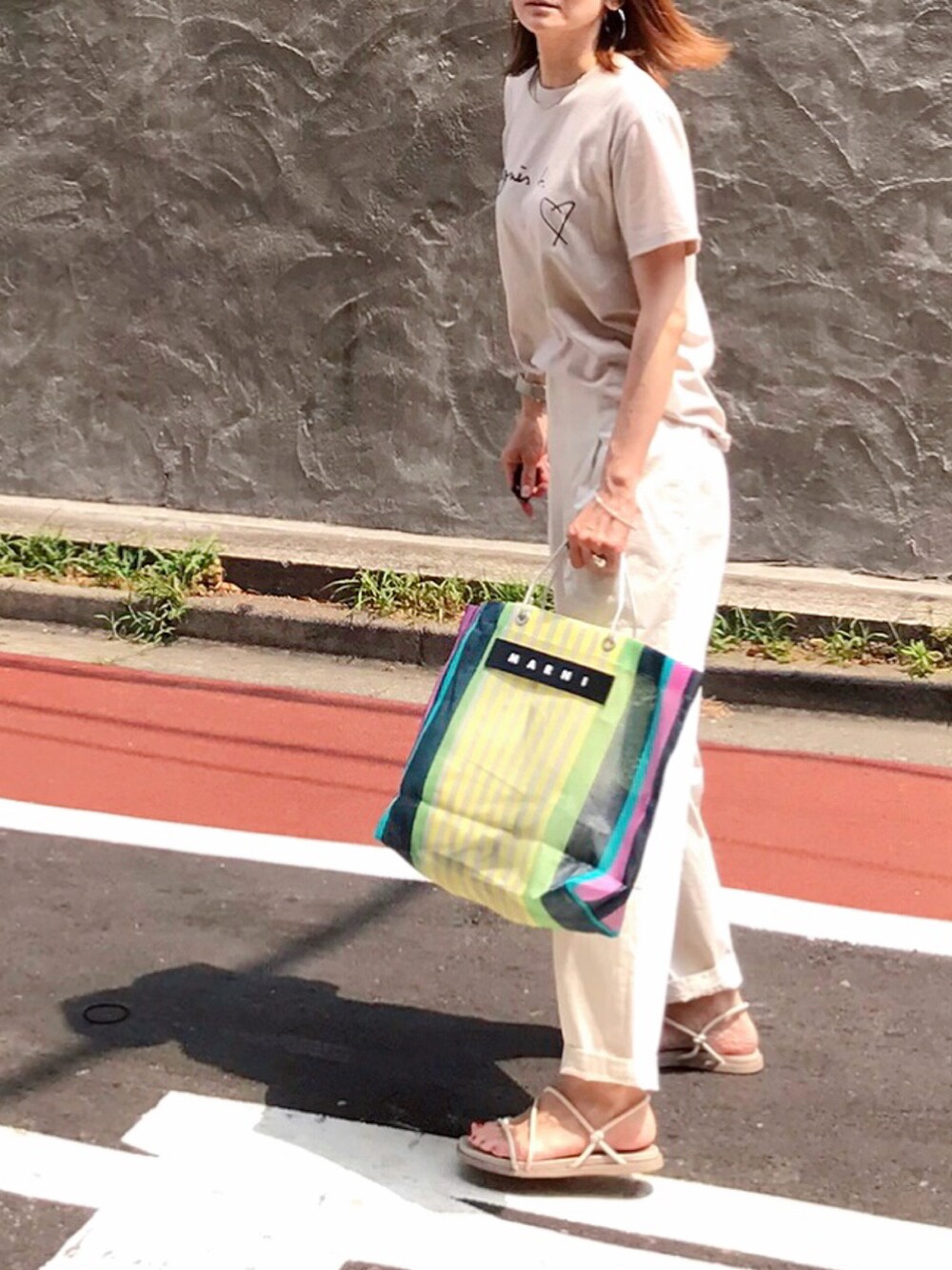 ベージュ系のTシャツ/カットソー、その他のバッグ、ホワイト系のその他パンツを着用したレディースの夏コーディネートの3枚目の写真