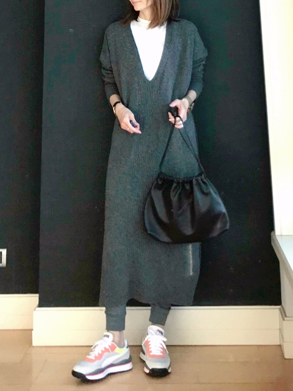 ブラウン系のハンドバッグ、グレー系のワンピース、グレー系のスニーカーを着用したレディースの冬コーディネートの2枚目の写真