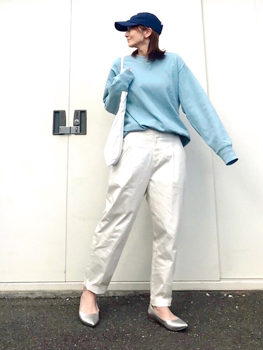 ブルー系のスウェット、ホワイト系のトートバッグ、ホワイト系のその他パンツを着用したレディースの冬コーディネートの2枚目の写真