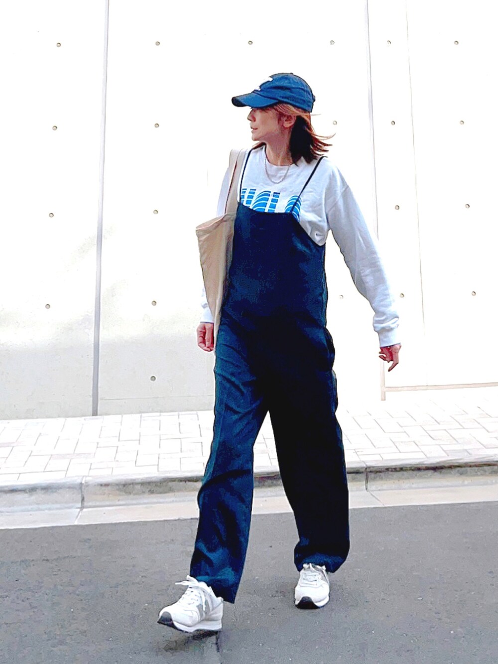 ブルー系のつなぎ/オールインワン、ホワイト系のスウェット、ホワイト系のスニーカーを着用したレディースの春コーディネートの3枚目の写真